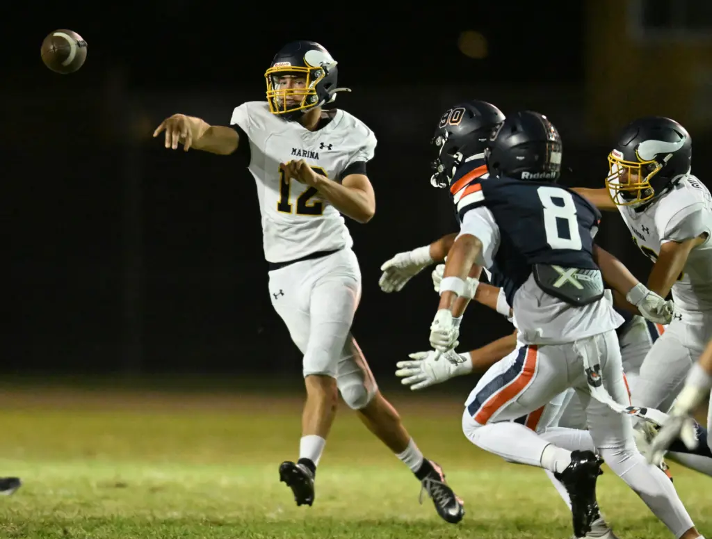 Quarterback Maverick Coverick #12 of Marina passes in the first...