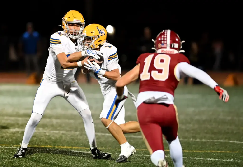 La Serna Lancers defensive lineman Douglas Deleon (12) hands off...