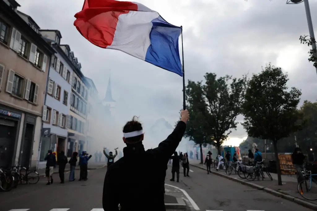 A protester holds a French flag during a demonstration against...