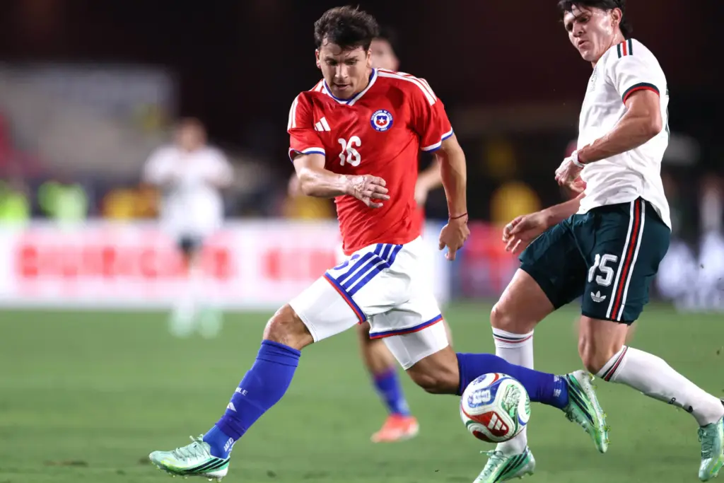 Chile forward Gonzalo Tapia, left, tries to recover the ball...