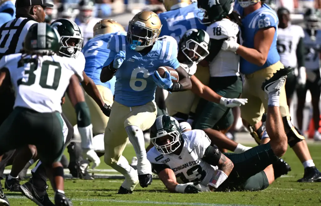 UCLA running back Anthony Woods (6) scores on a 4-yard...