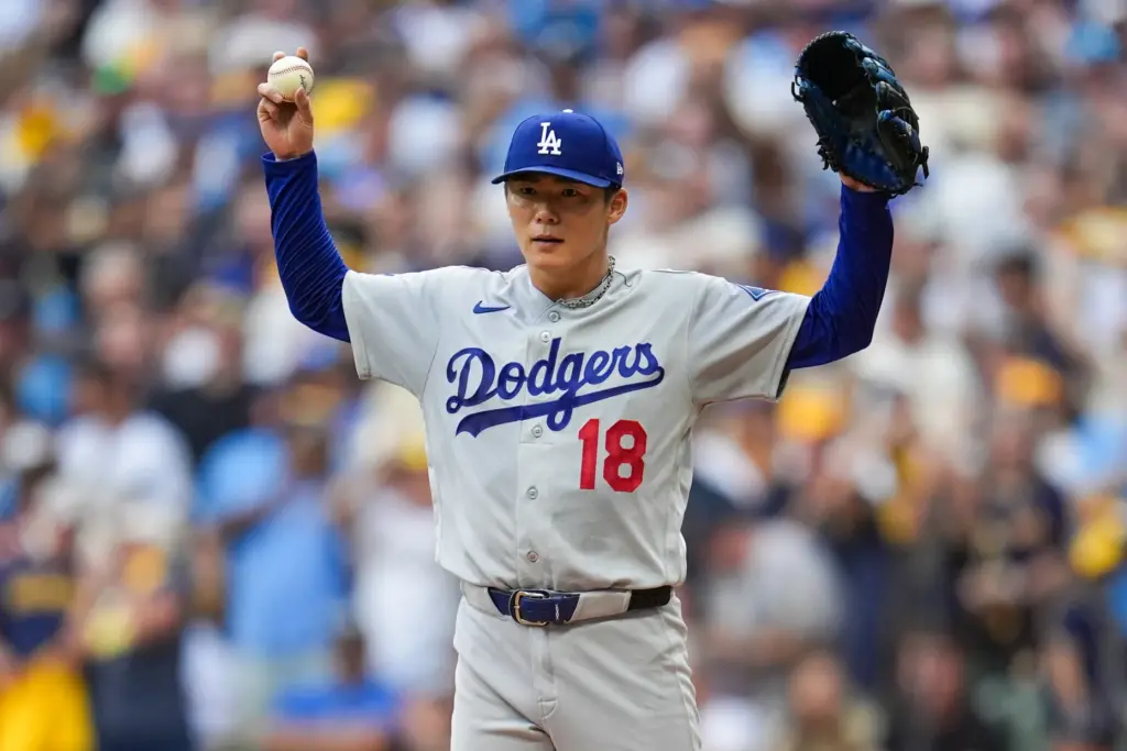 Dodgers starting pitcher Yoshinobu Yamamoto motions after giving up a...