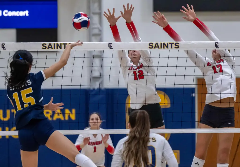 Crean Lutheran outside hitter Olivia Kim (15), left, hits the...