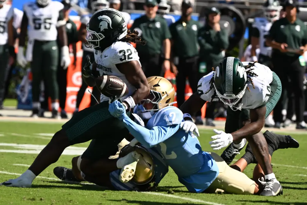 UCLA defensive back Malik Hartford (12) forces a fumble by...
