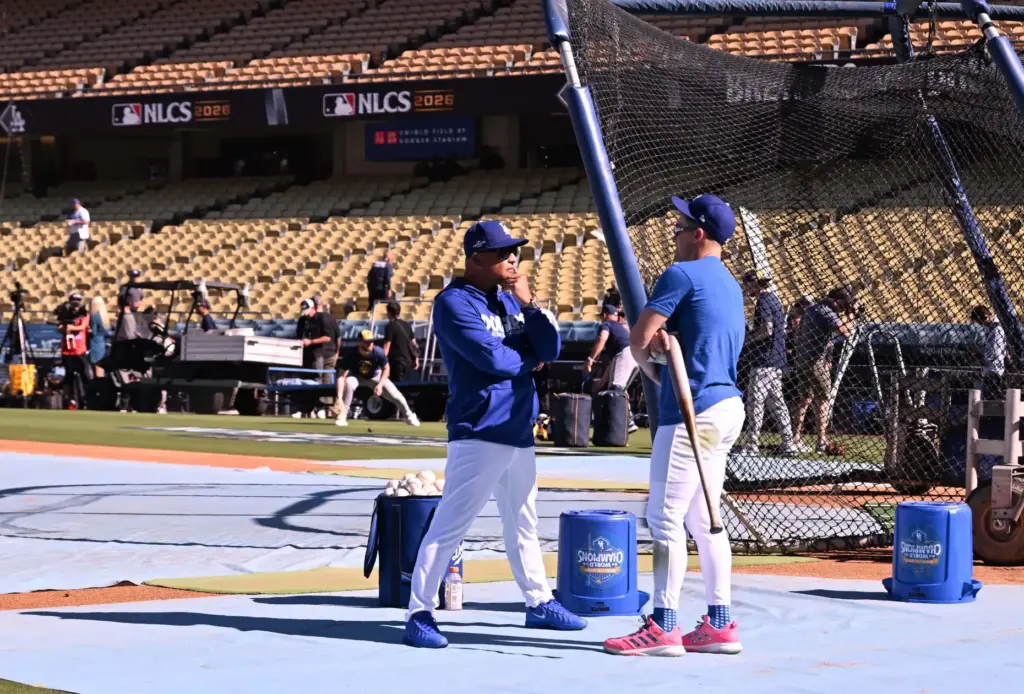 Dodgers manager Dave Roberts, left, speaks with utility player Kike...