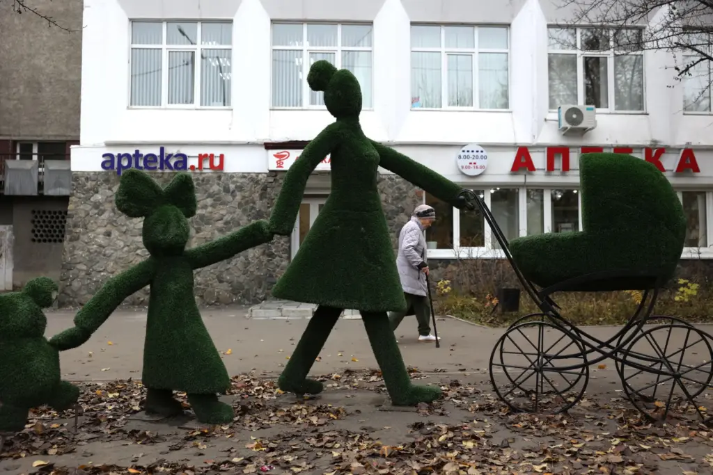 An elderly woman walks past a pharmacy in Shelekhov, Russia.