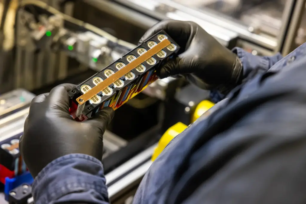 A worker checks over a lithium-ion battery module inside Viridi’s...