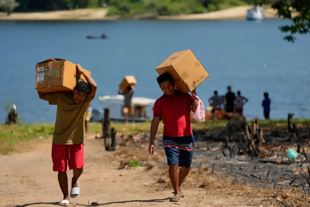 Men, who are part of the Arapium Indigenous group, carry...