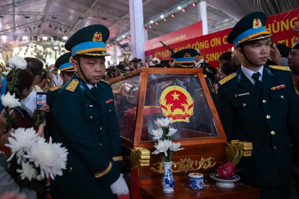 People watch as remains are transferred for burial at Vietnam's Martyr's Cemetery.