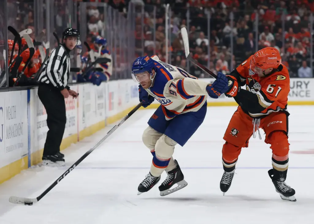 Edmonton Oilers star Connor McDavid, left, fends off the Ducks’...