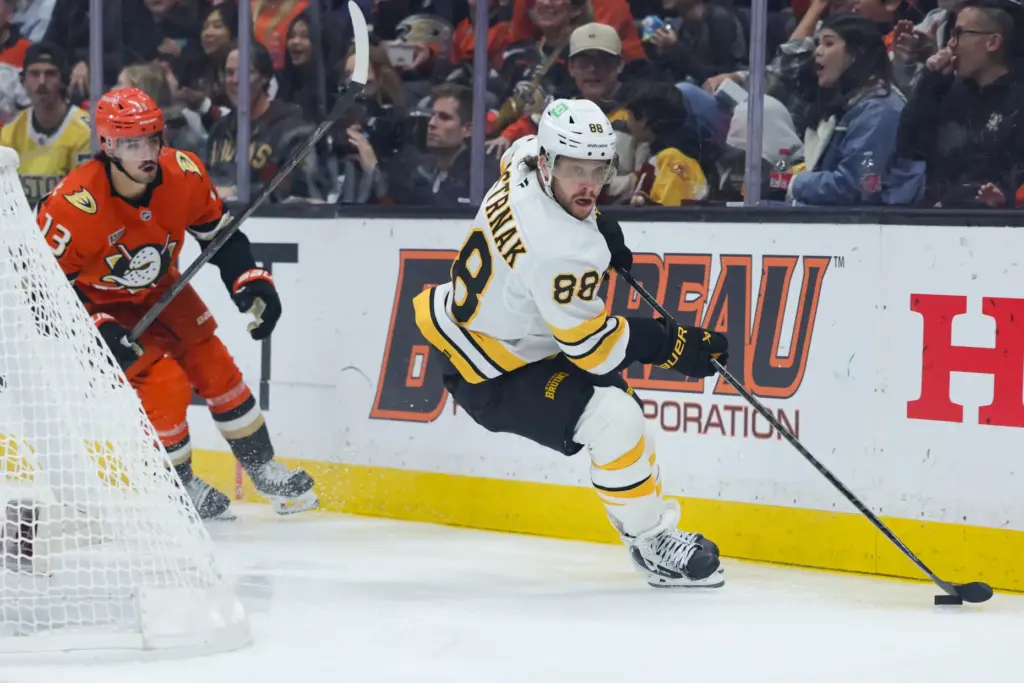 Boston Bruins right wing David Pastrnak, right, moves the puck...