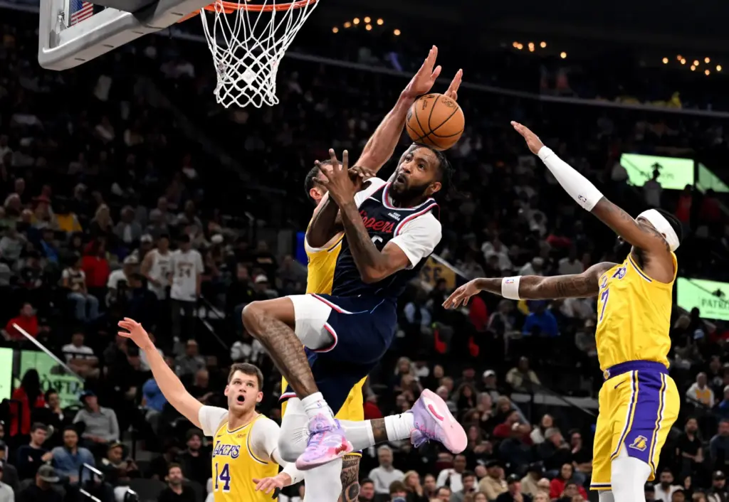 Clippers forward Derrick Jones Jr., middle, is fouled by Lakers...