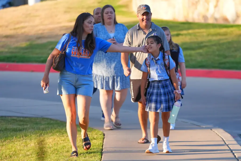 Parents and children walk together on the first day of classes at Covenant Christian Academy.