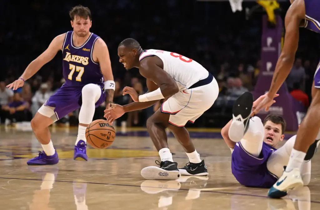 Clippers guard Kris Dunn, middle, reaches for a loose ball...