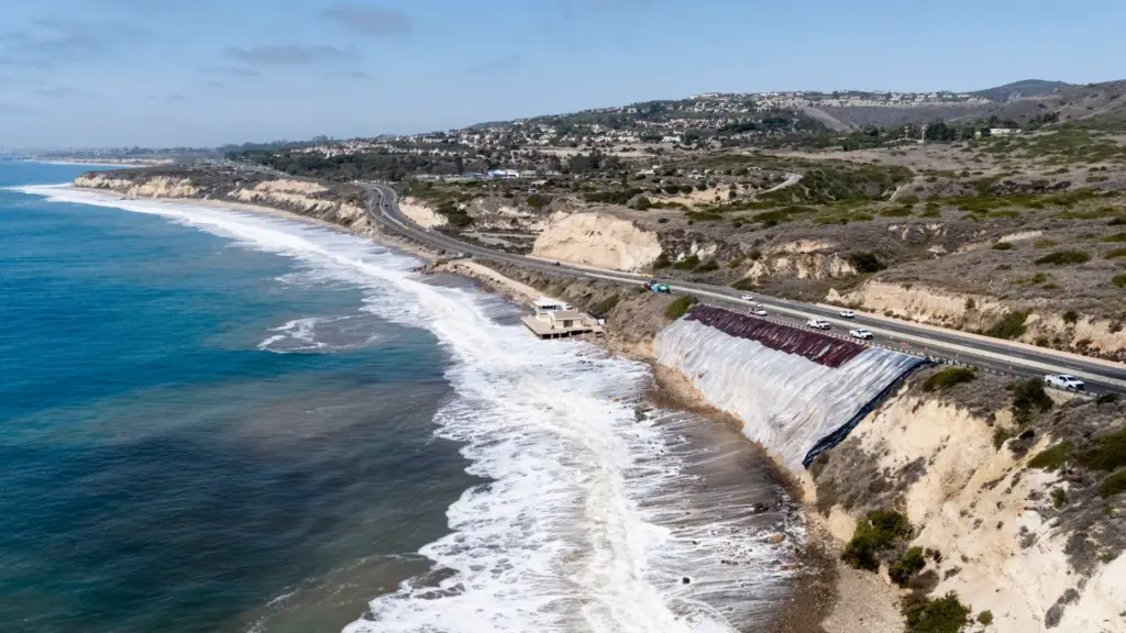 A tarp covers a crumbling bluff along Pacific Coast Highway...