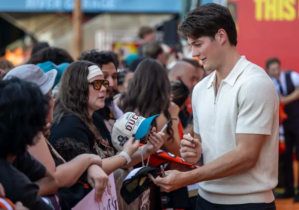 Ducks player Judd Caulfield signs autographs on the orange carpet...