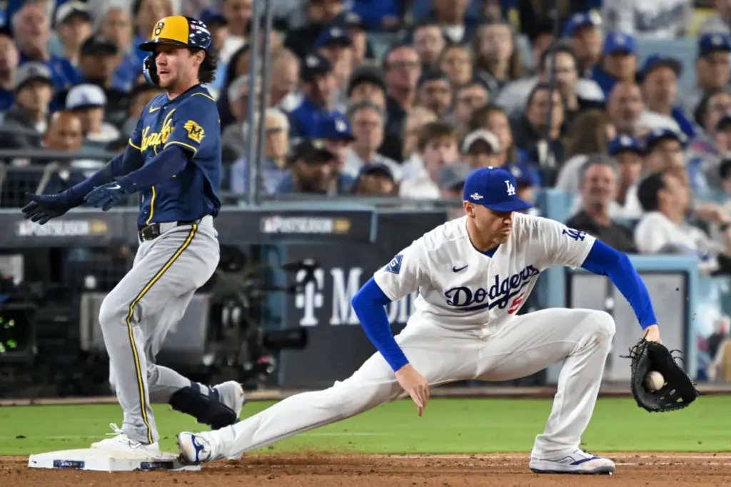 The Milwaukee Brewers’ Brice Turang, left, is safe at first...