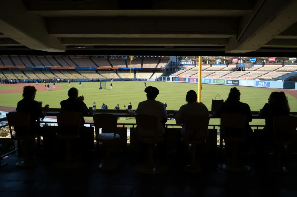 Dodger staffers watch warm-ups before Game 3 of the National...