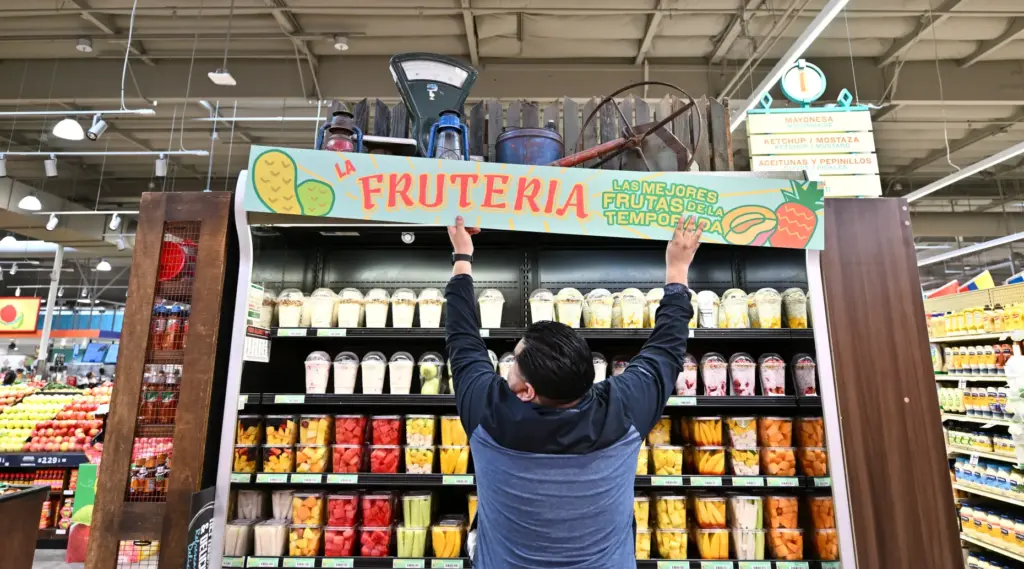 Jorge Dominguez hangs a sign during opening day of Mercado...