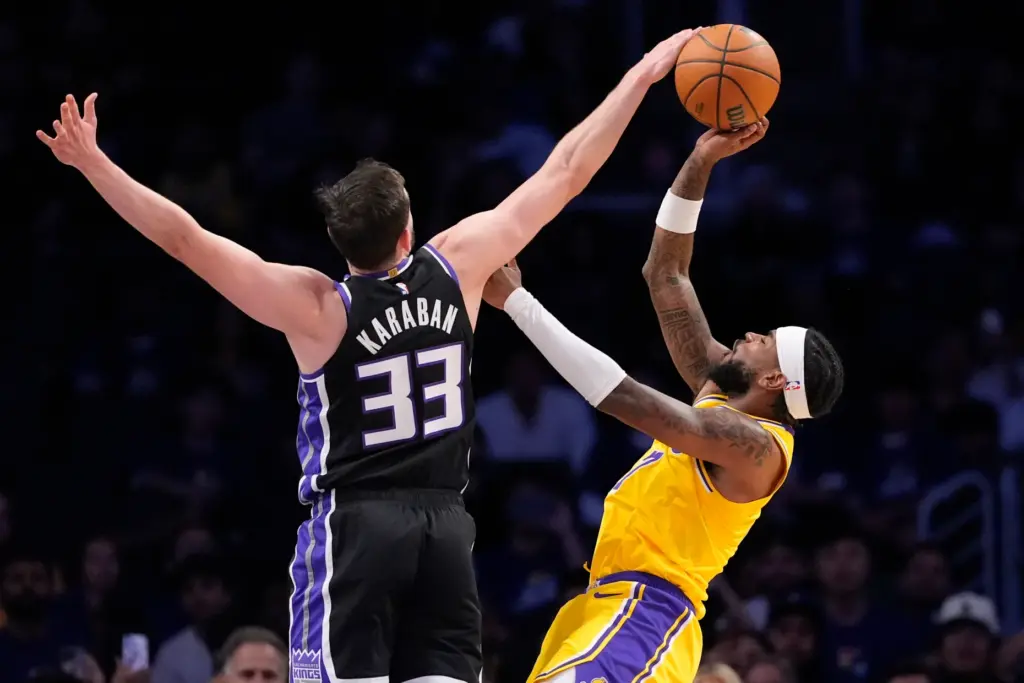Lakers guard Jaden Hardy, right, has his shot blocked by...