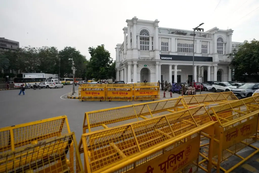 Barricades are erected ahead of a tricolor (Indian flag) waving...