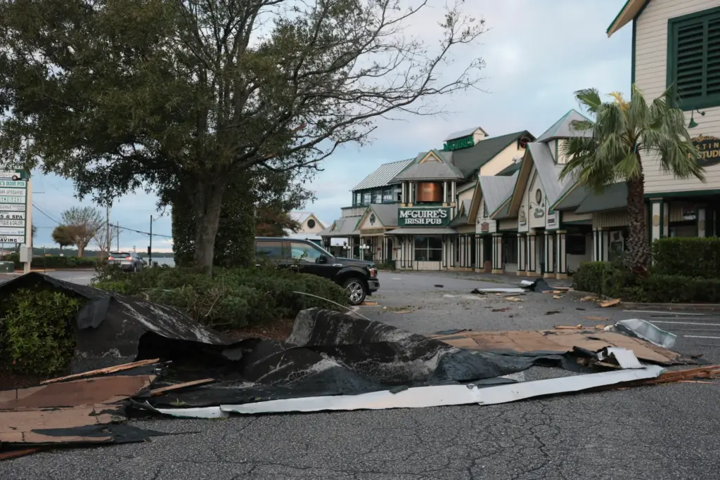 Roofing material lies on the ground after Hurricane Isaias tore...