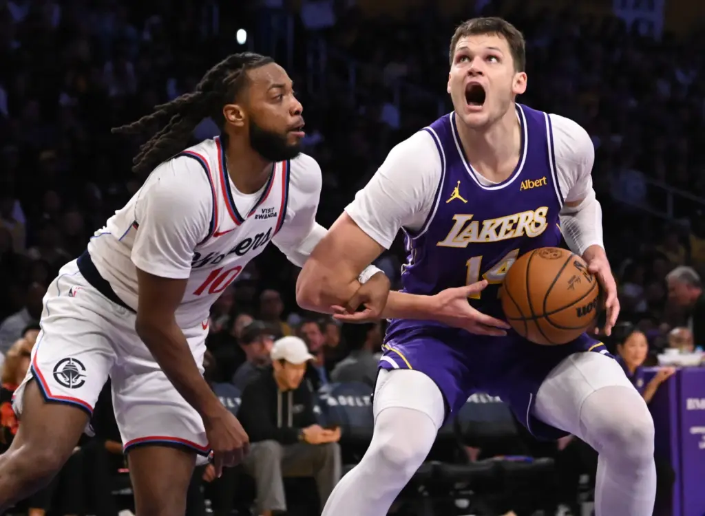 Lakers center Walker Kessler, right, is fouled by Clippers guard...