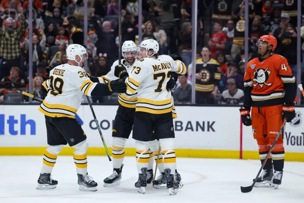 Boston Bruins center Elias Lindholm celebrates with teammates after scoring...