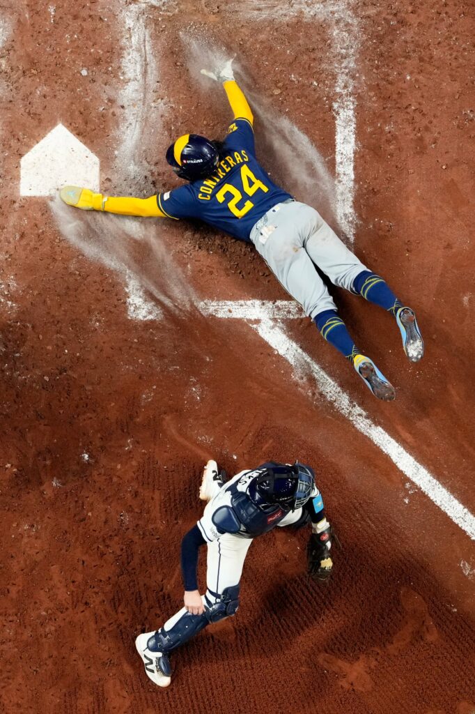The Milwaukee Brewers’ William Contreras slides home to score past...