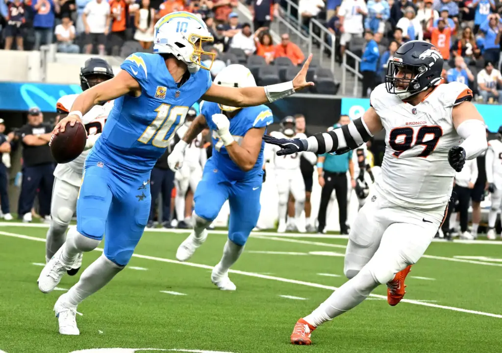 Chargers quarterback Justin Herbert (10) tries to avoid Denverâs Zach...