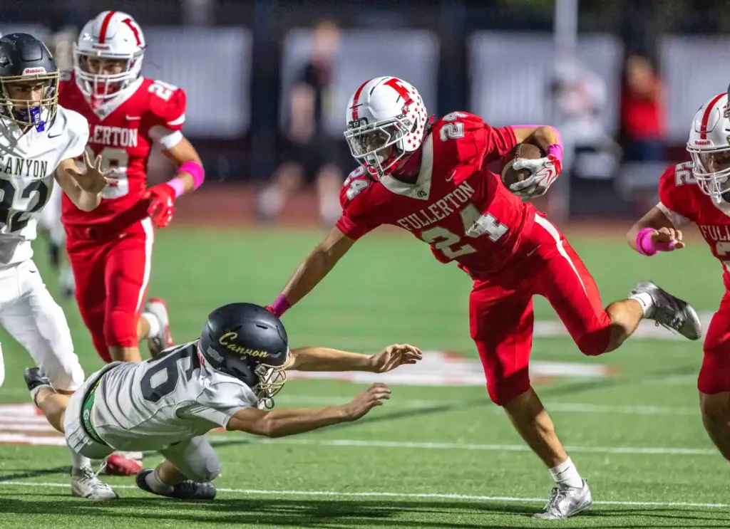 Fullerton wide receiver Nathan Vejar (24) breaks a tackle while...