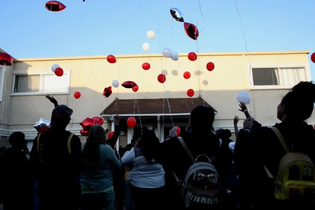 Mourners release balloons during a candlelight vigil in Long Beach...