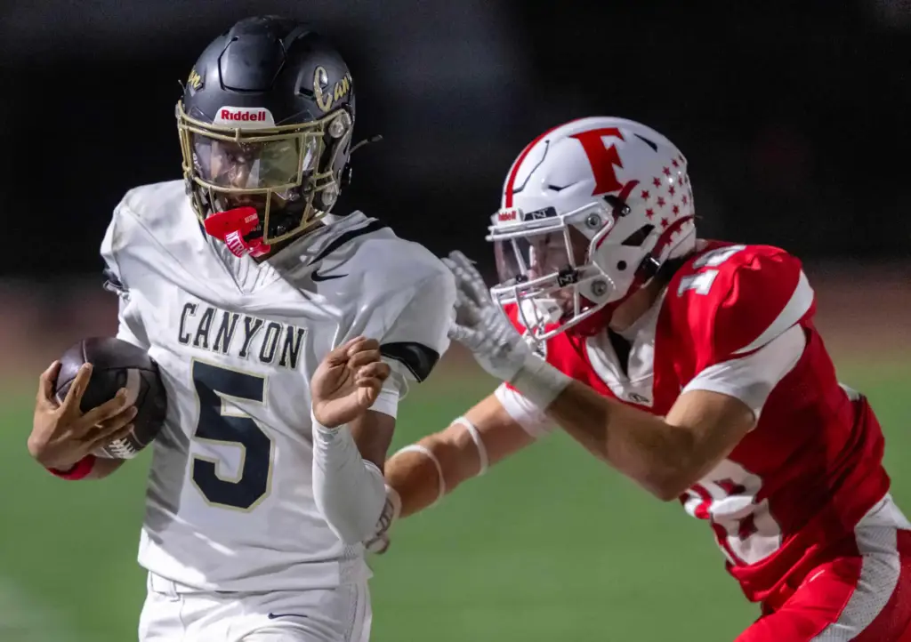 Canyon quarterback Kayden Phillips (5) carries the ball on a...