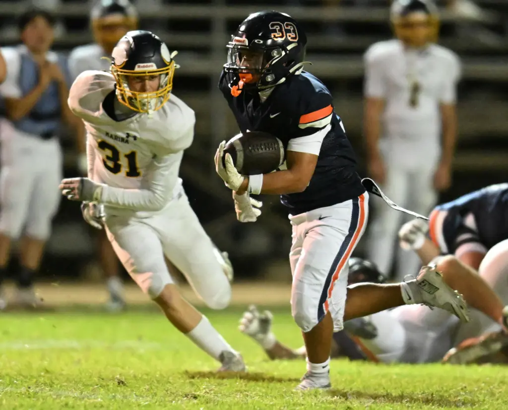 Tyler Hauber #33 of Marina runs past Logan Jump #31...