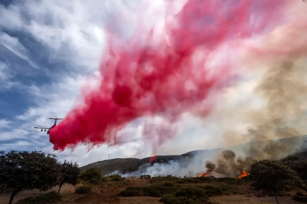A fixed wing aircraft drops fire retardant on the Norte...