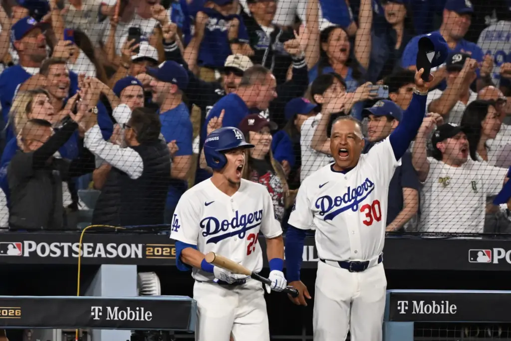 Dodgers manager Dave Roberts, right, reacts in the dugout next...