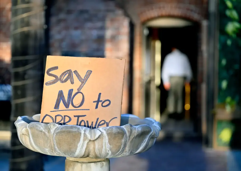 A sign sits in a courtyard fountain as residents get...