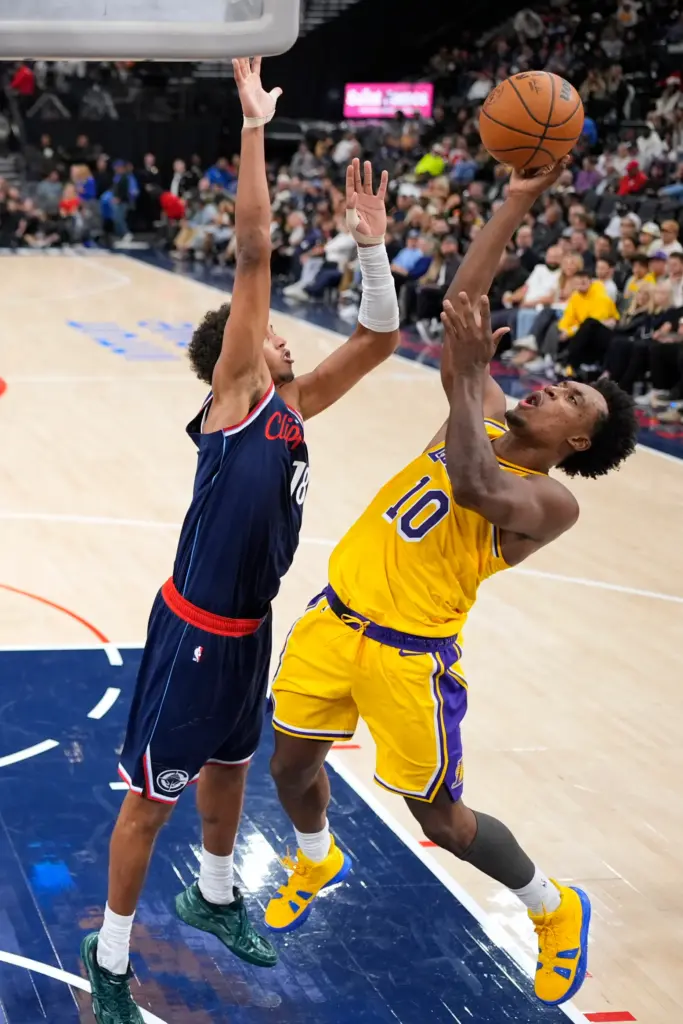 Lakers guard Collin Sexton, right, shoots as Clippers forward Baba...