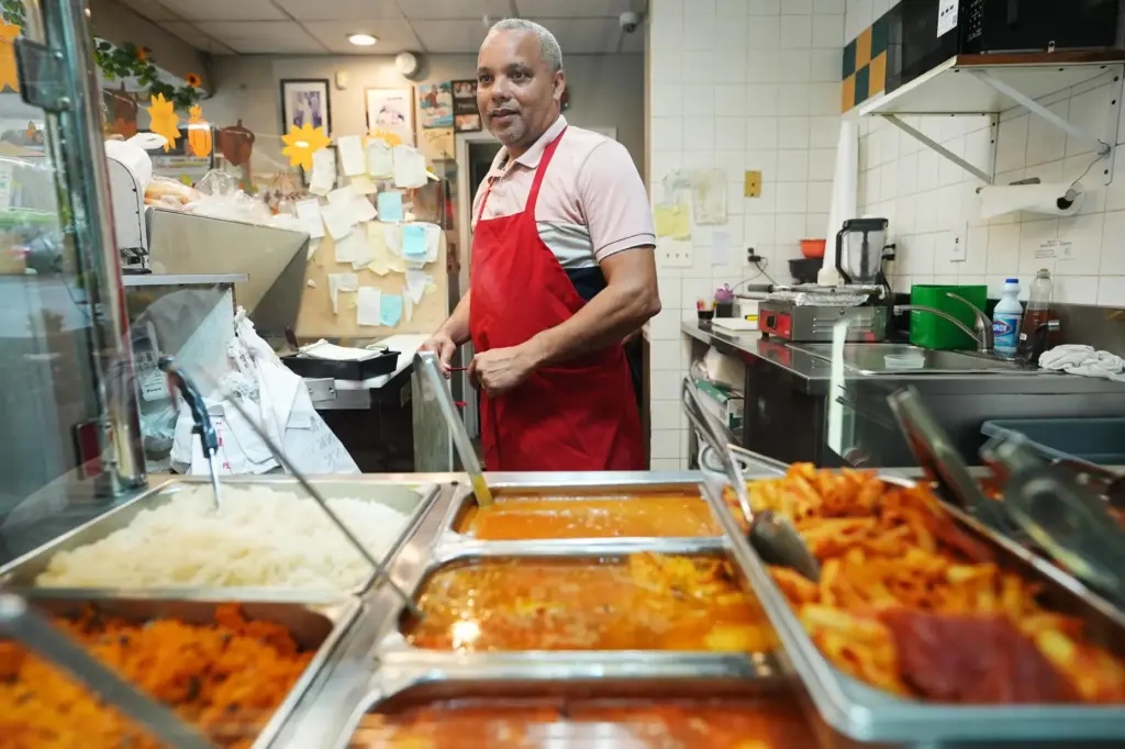 Alberto Pena puts on his apron at Las Palmas Restaurant.