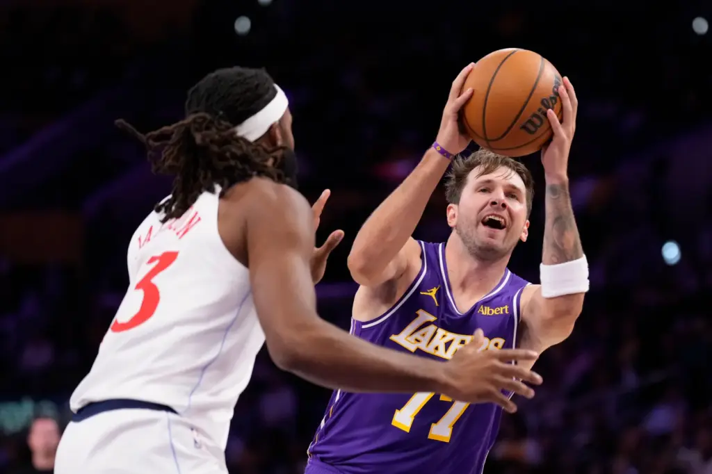 Lakers star Luka Doncic, right, looks to shoot as Clippers...