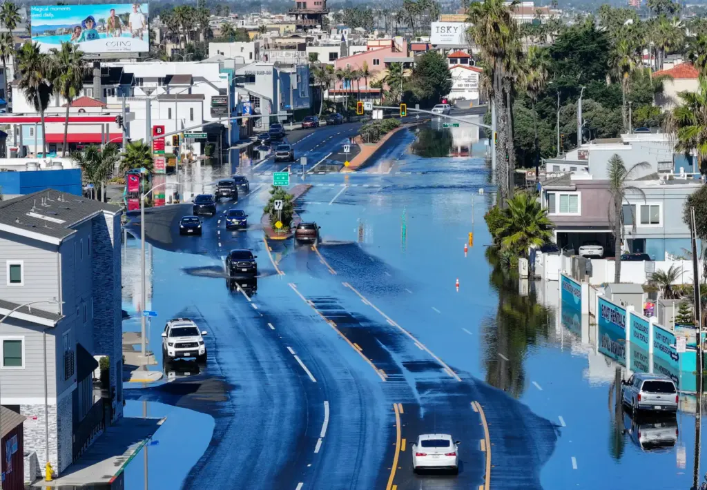 Sea water floods on to Pacific Coast Highway during high...