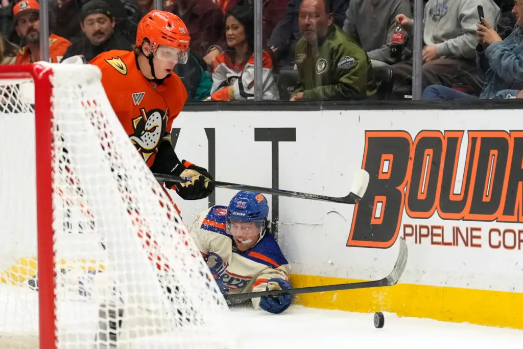 Edmonton Oilers left wing Isaac Howard, right, falls to the...