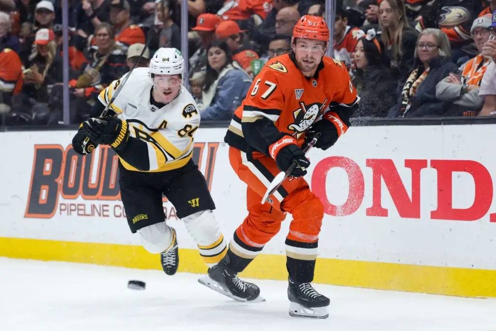 Ducks defenseman Tristan Luneau, right, moves the puck as Boston...