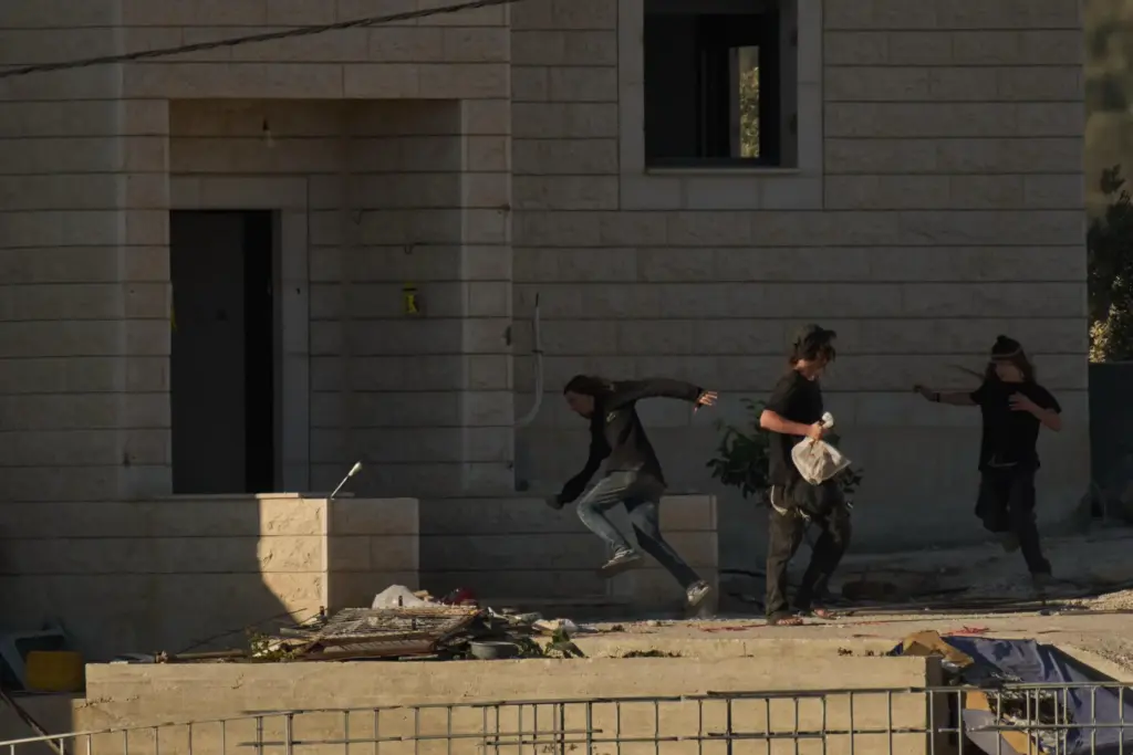FILE – Israeli settlers are seen at one of the...