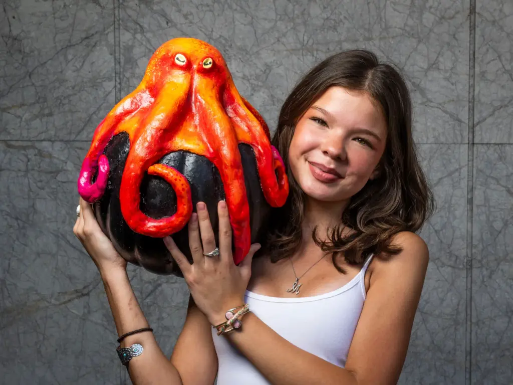 Scarlett Becerra holds her pumpkin titled â8 Arms After Darkâ...