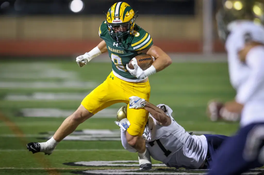Edisonâs Samuel Edmisten, left, evades a tackle attempt by San...