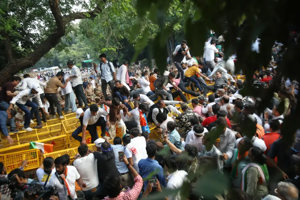 Activists and workers from various opposition parties try to breach police barricades.