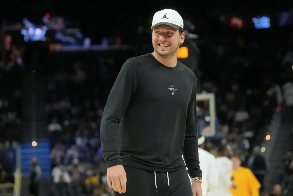 Lakers star Luka Doncic smiles while walking on the court...