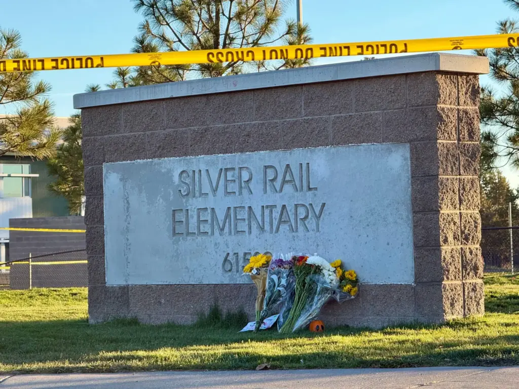 Flowers are placed beside a sign at Silver Rail Elementary...