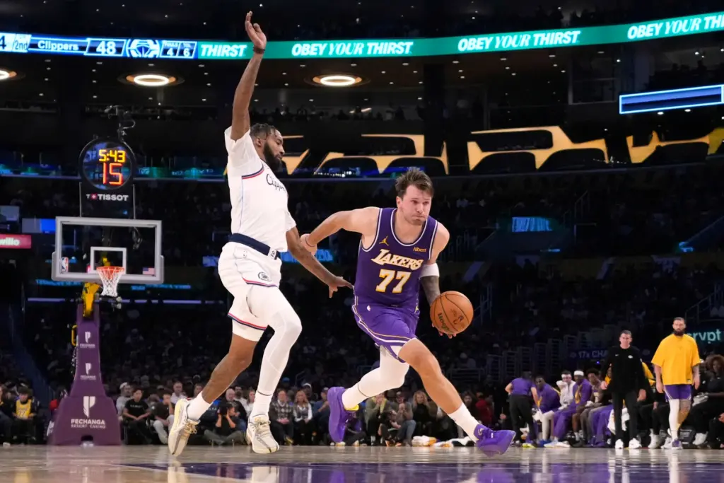 Lakers star Luka Doncic, right, drives as Clippers forward Derrick...